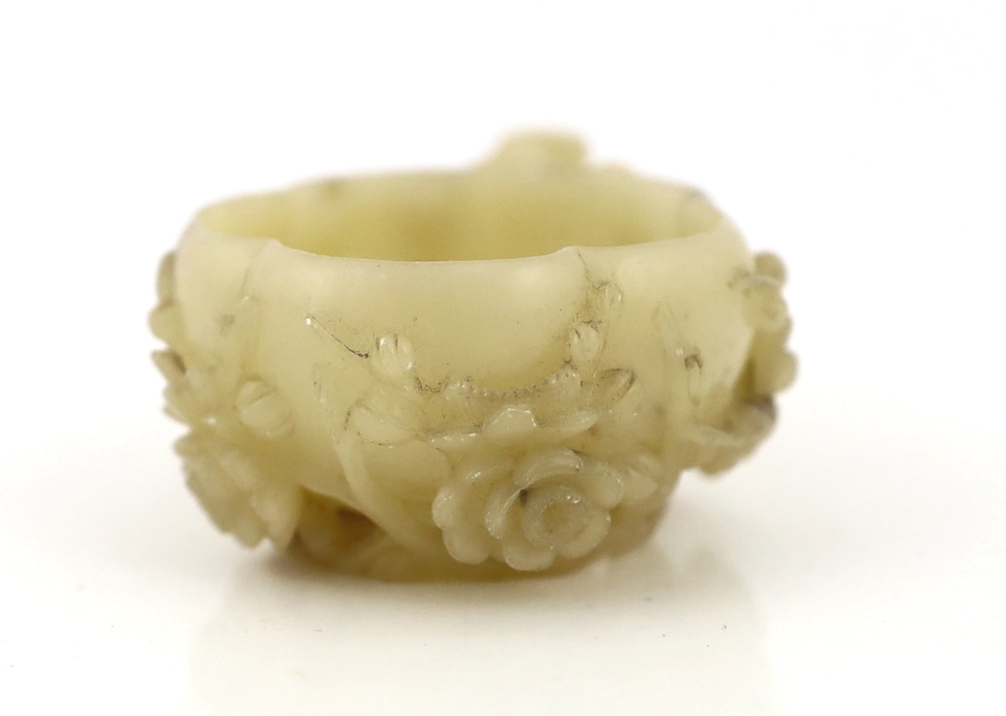 A Chinese creamy white soapstone ‘plum blossom’ cup, 18th/19th century, carved in high relief and open work with prunus branches and blossom, the stone of creamy white tone with some pale russet inclusions, 7.4cm across